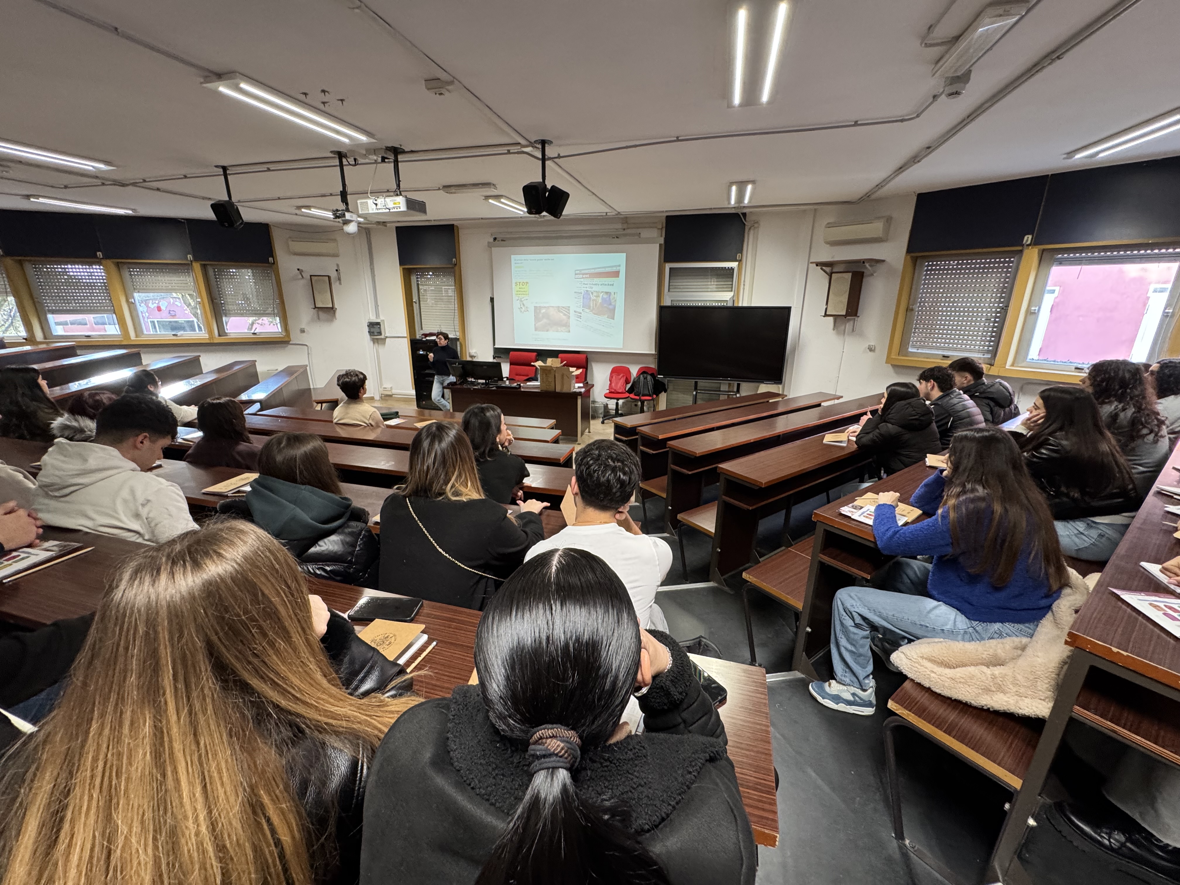 Aula del Dipartimento di Medicina Veterinaria dell'Università di Sassari con studenti durante presentazione informativa: slide proiettate e confronto sul percorso di studi in veterinaria
