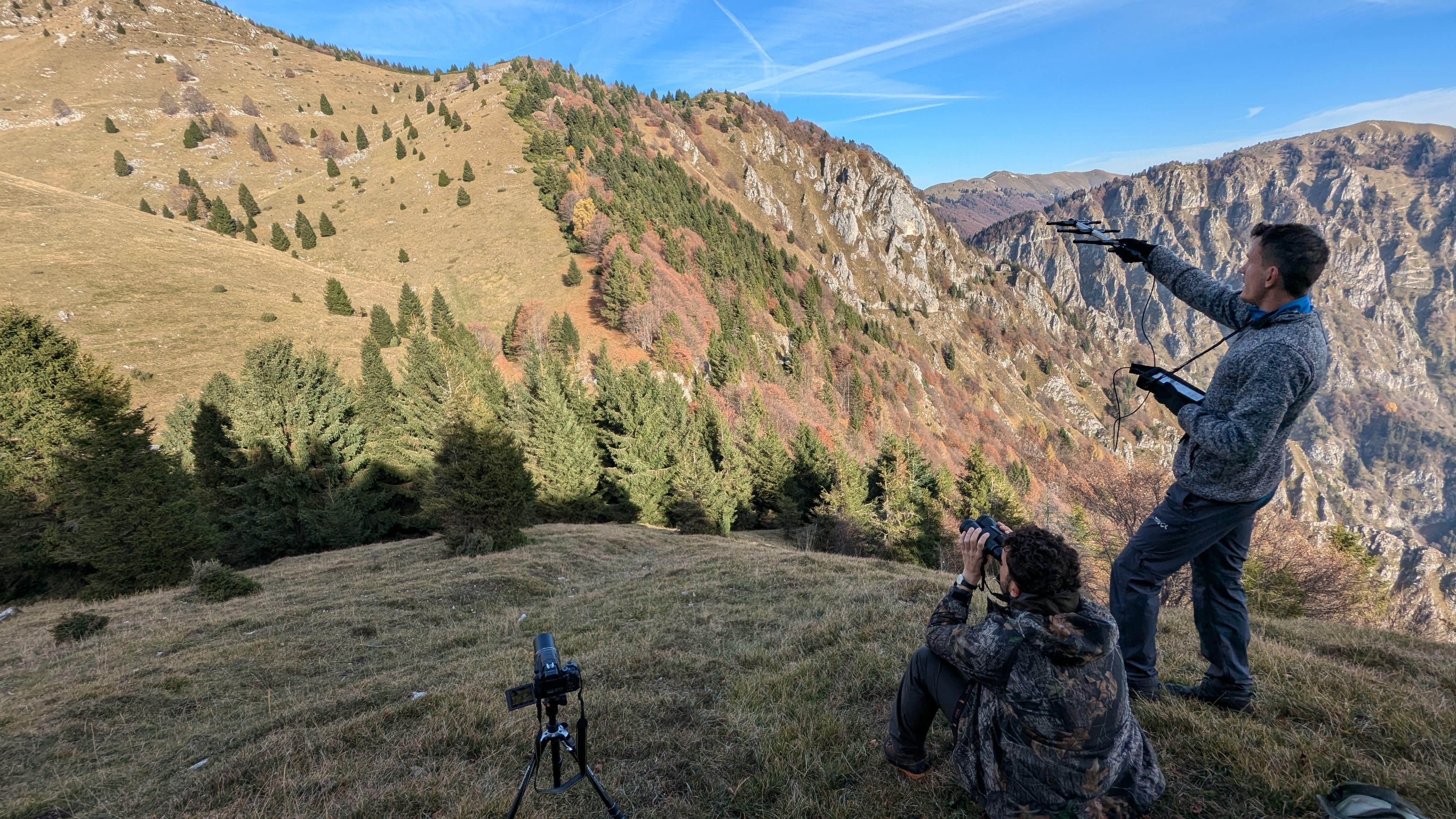 Ricercatori in montagna utilizzano drone e fotocamera per osservazione della fauna selvatica e raccolta dati sul territorio