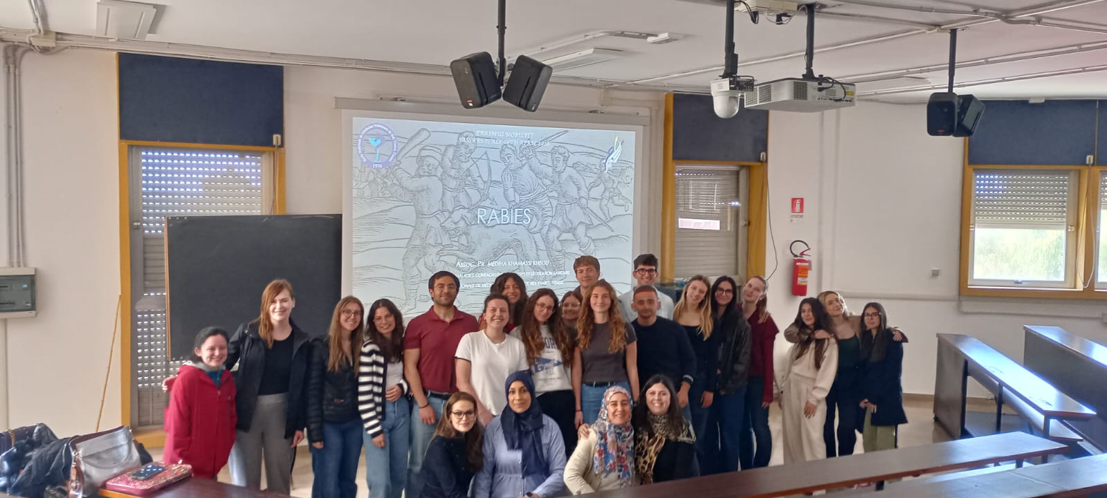 Foto di gruppo in aula universitaria con studenti e docenti al termine di una giornata di formazione o di un seminario scientifico.