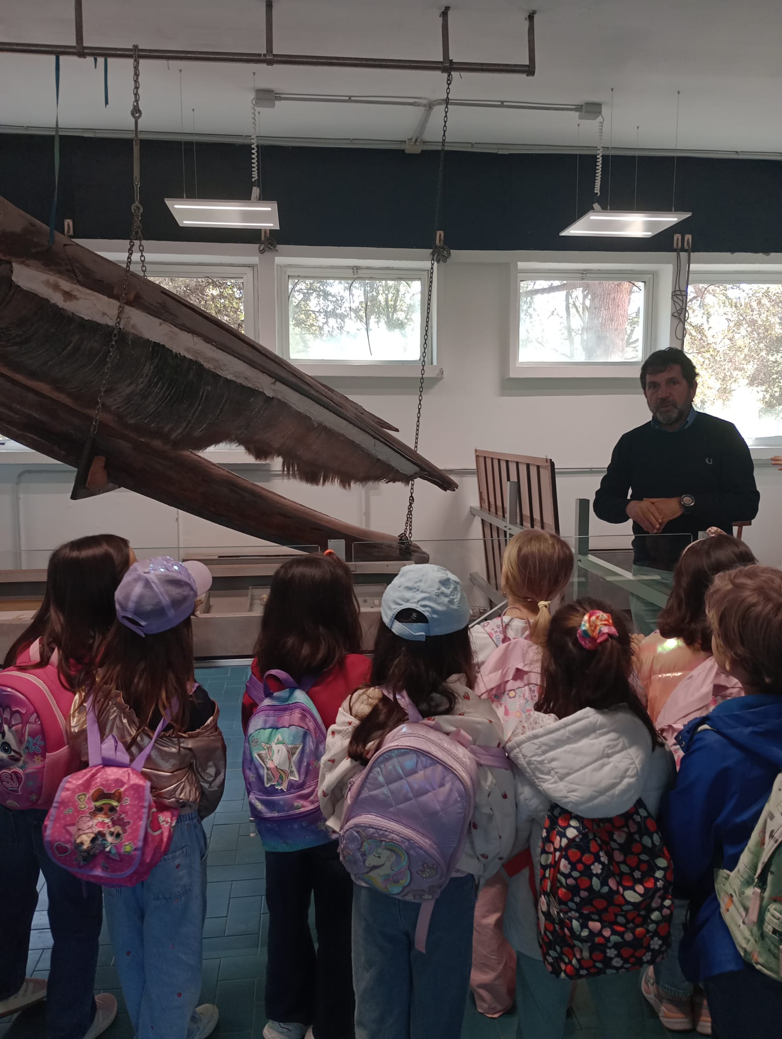 Alunni della scuola primaria in visita didattica nell'aula Balena, mentre osservano il grande scheletro di balena accompagnati dagli insegnanti