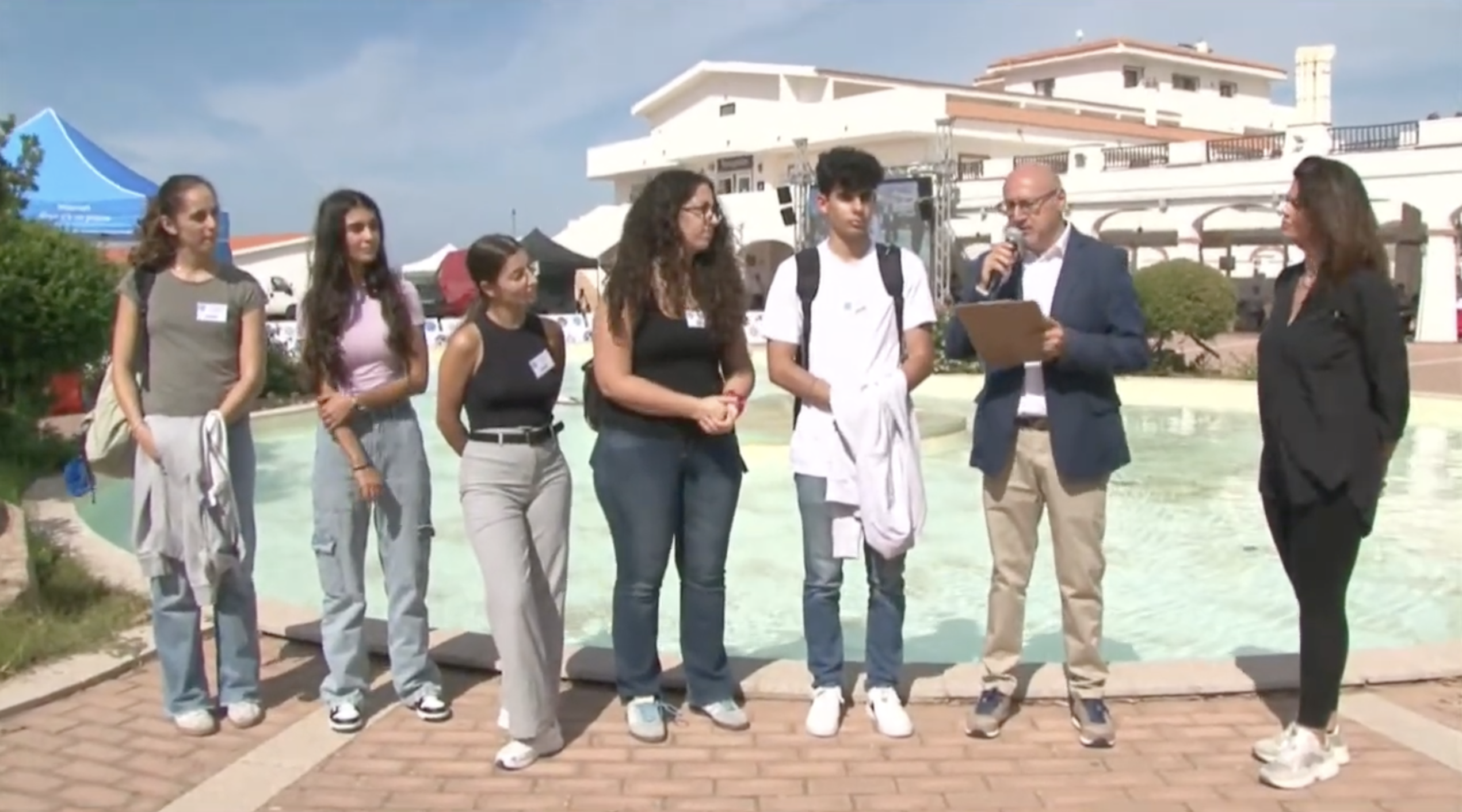 Quattro studentesse e uno studente di VetSassari durante l’intervista trasmessa in diretta streaming all’Expo internazionale canina, accanto al presentatore con il microfono.