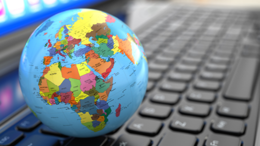 Piccolo mappamondo poggiato sopra la tastiera di un computer