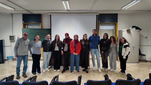 Foto di gruppo in aula universitaria con studenti e docenti al termine di una giornata di formazione o di un seminario scientifico.