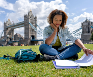 Ragazza che studia seduta sul prato